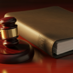 Judge's gavel resting beside a thick leather-bound book on a polished wooden desk, evoking legal proceedings.