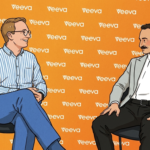Two men sit in chairs facing each other on an orange backdrop covered with white Veeva logos, as if in an interview or discussion.